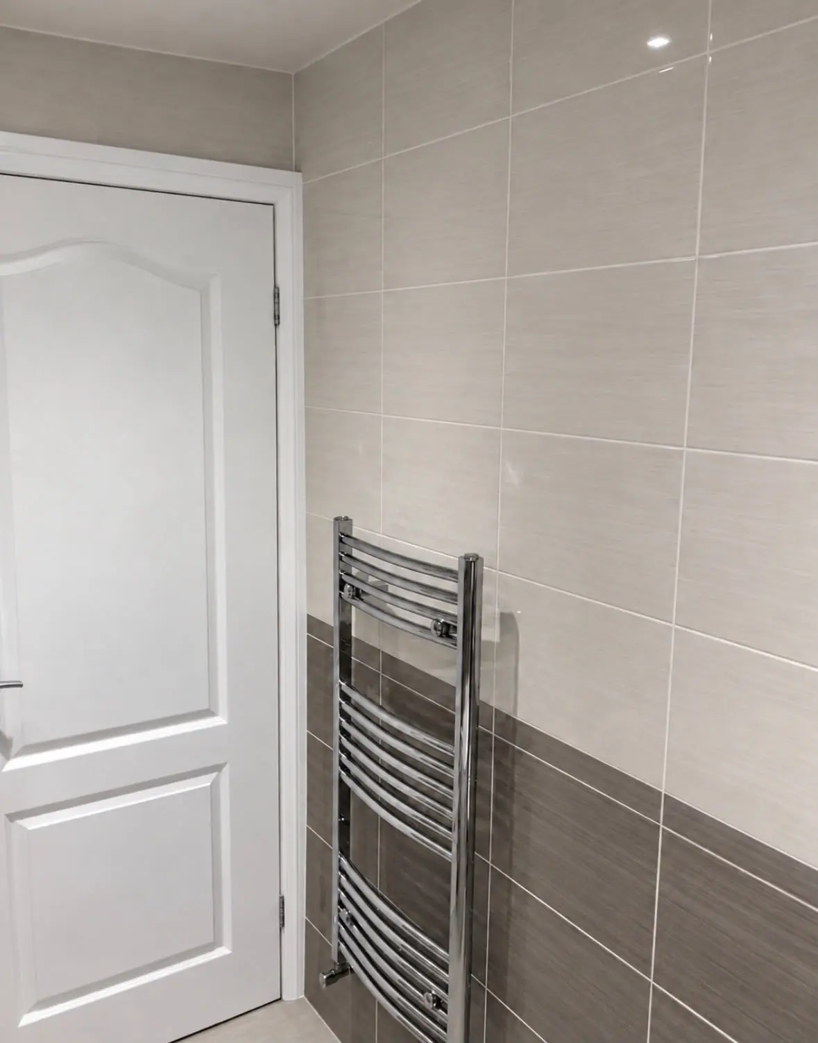 Chrome towel radiator beside the bathroom door