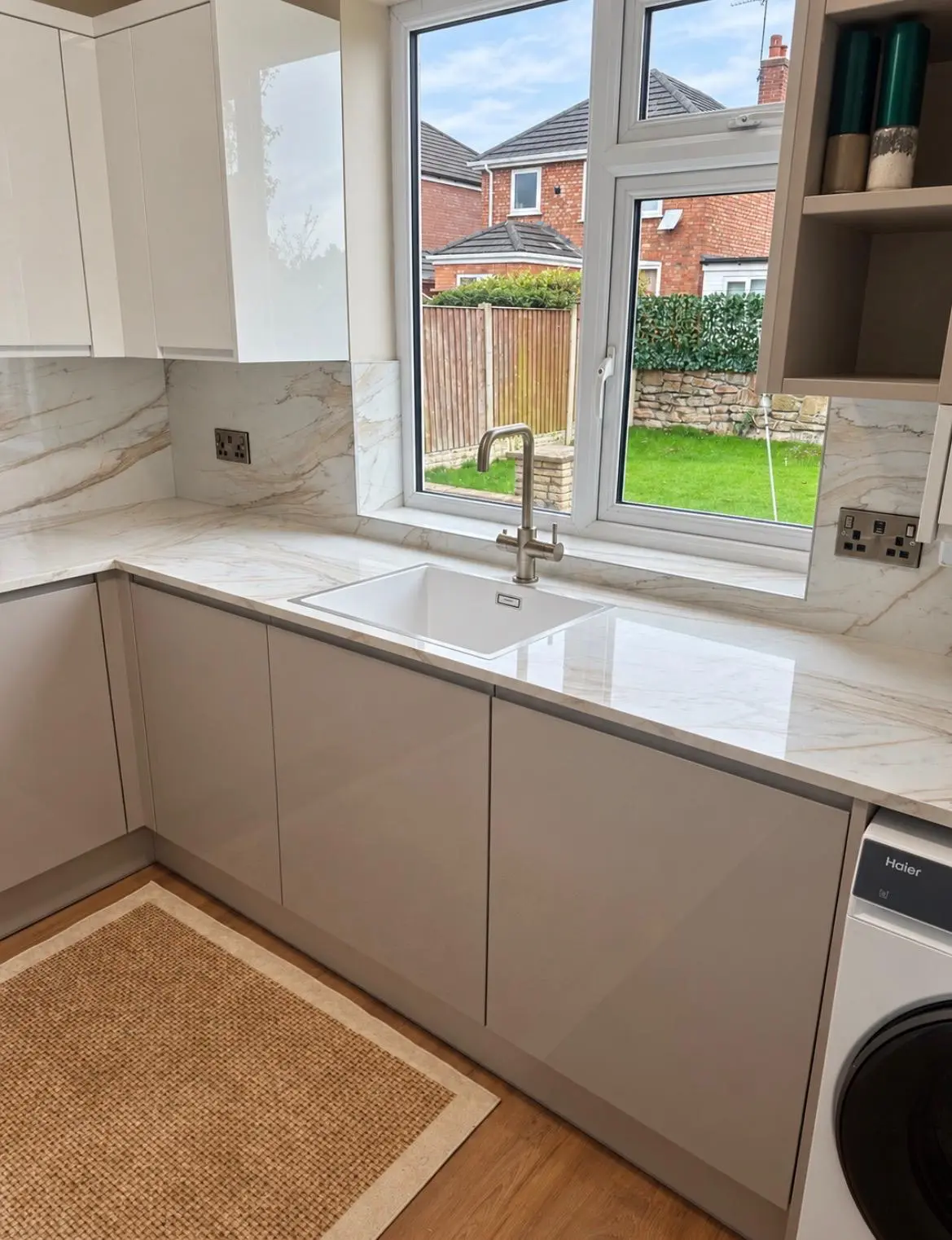 Marble-effect worktop running to the window, with a boiling-water tap at the sink