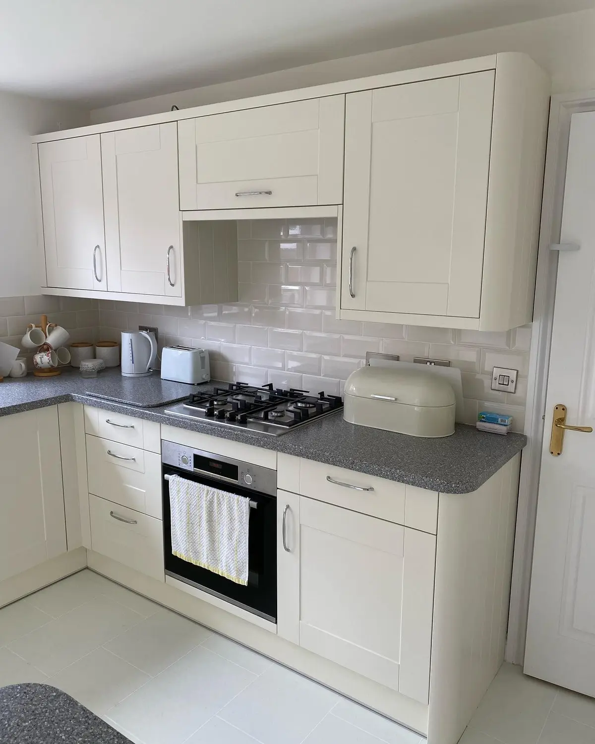 Cream shaker corner base units with grey quartz worktop