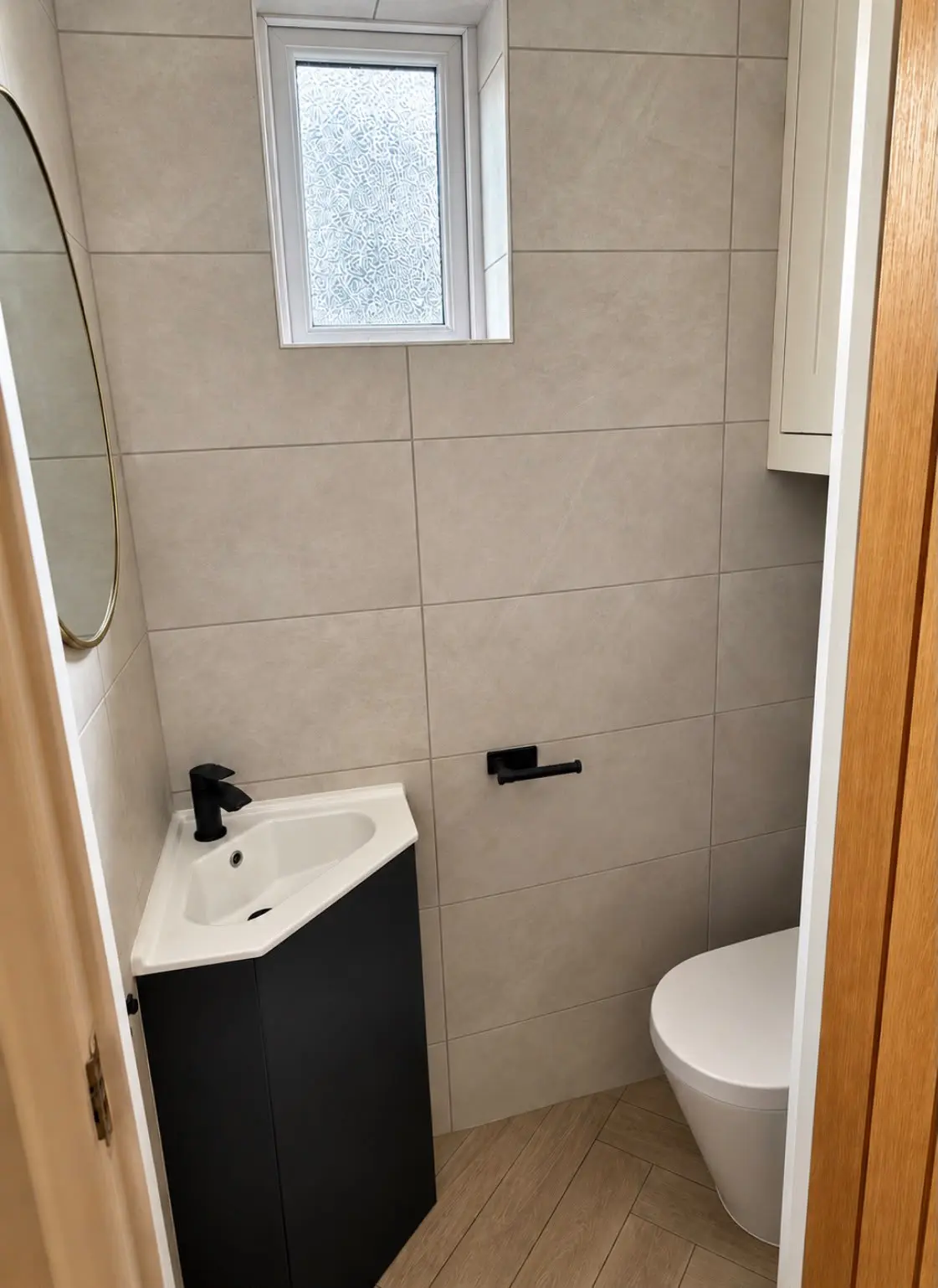 Corner vanity unit and back-to-wall WC beneath the window