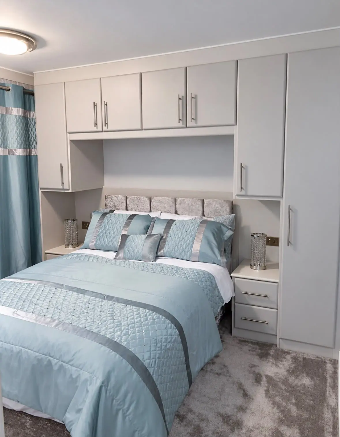 Fitted bedroom with light grey doors, overhead units and bedside units around the bed