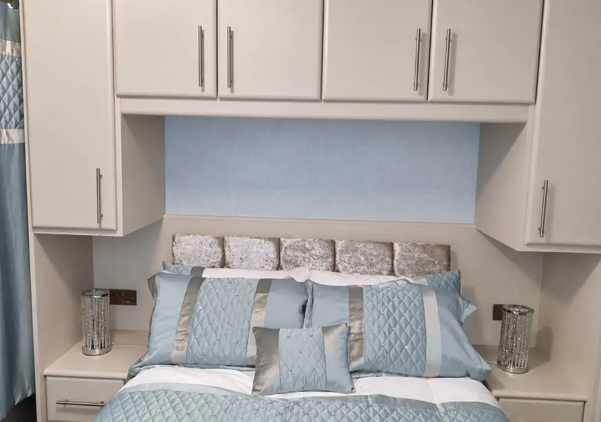 Overhead bridging units and bedside cabinets around the headboard