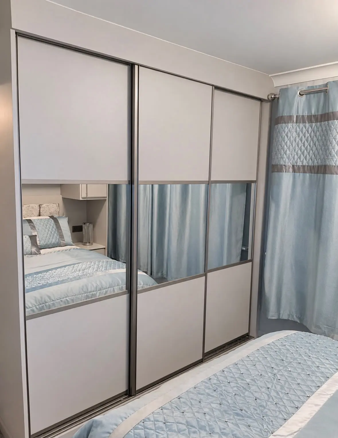 Split sliding wardrobe with mirrored centre panels in the finished bedroom