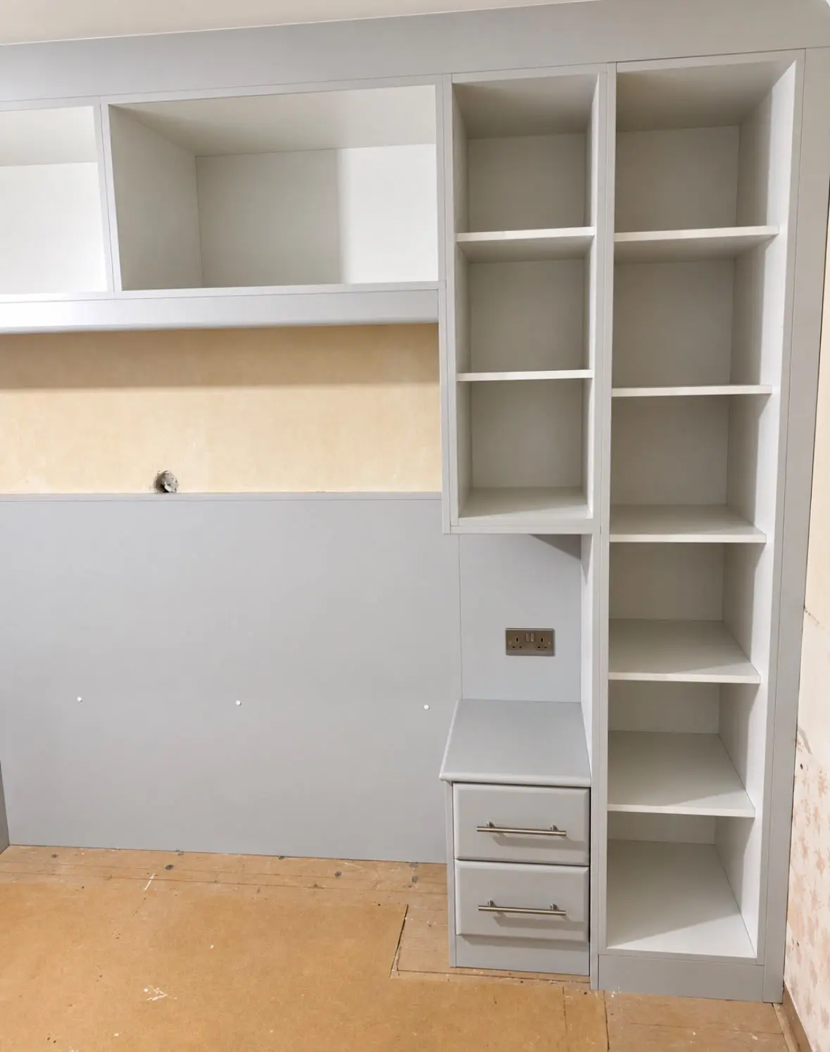 Bridging shelves and a tall open-shelf unit during installation