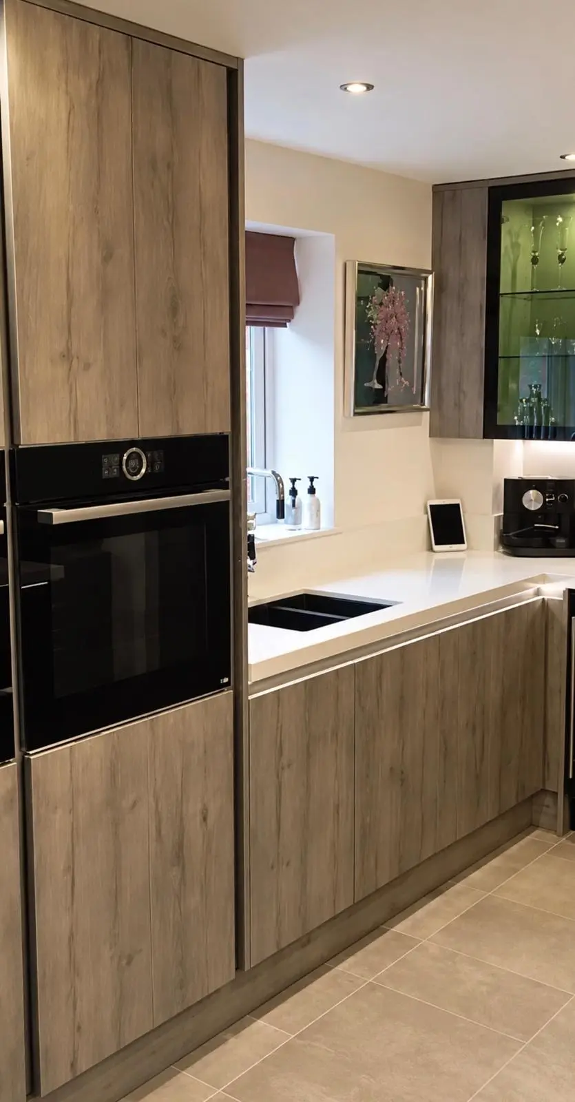Wood-effect tall housing with a built-in oven, and the sink run beyond