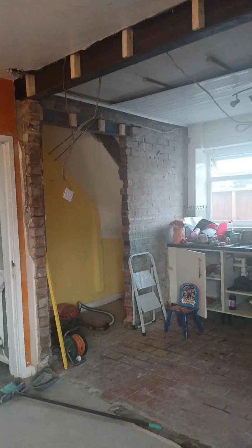 Work under the stairs, with the brickwork opened up beneath the new steels