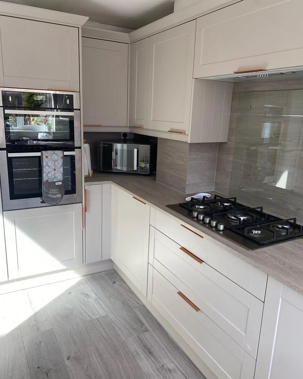 Light shaker kitchen with tall double-oven housing and gas hob
