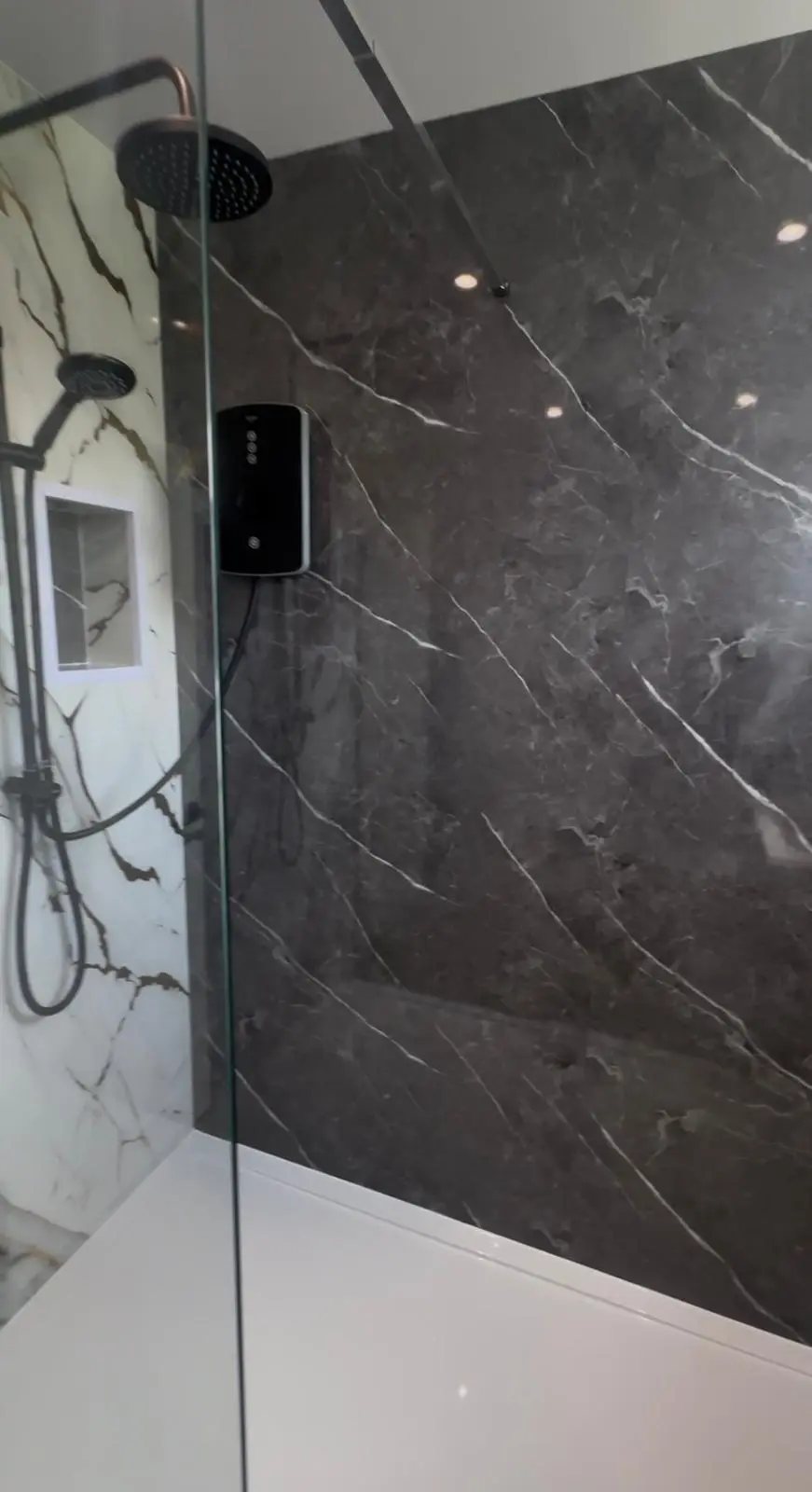Walk-in shower with a glass screen and black rail shower
