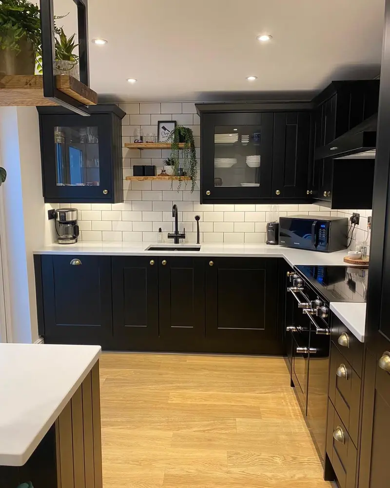 Matt black shaker kitchen with range cooker, glazed wall units and white metro tiling