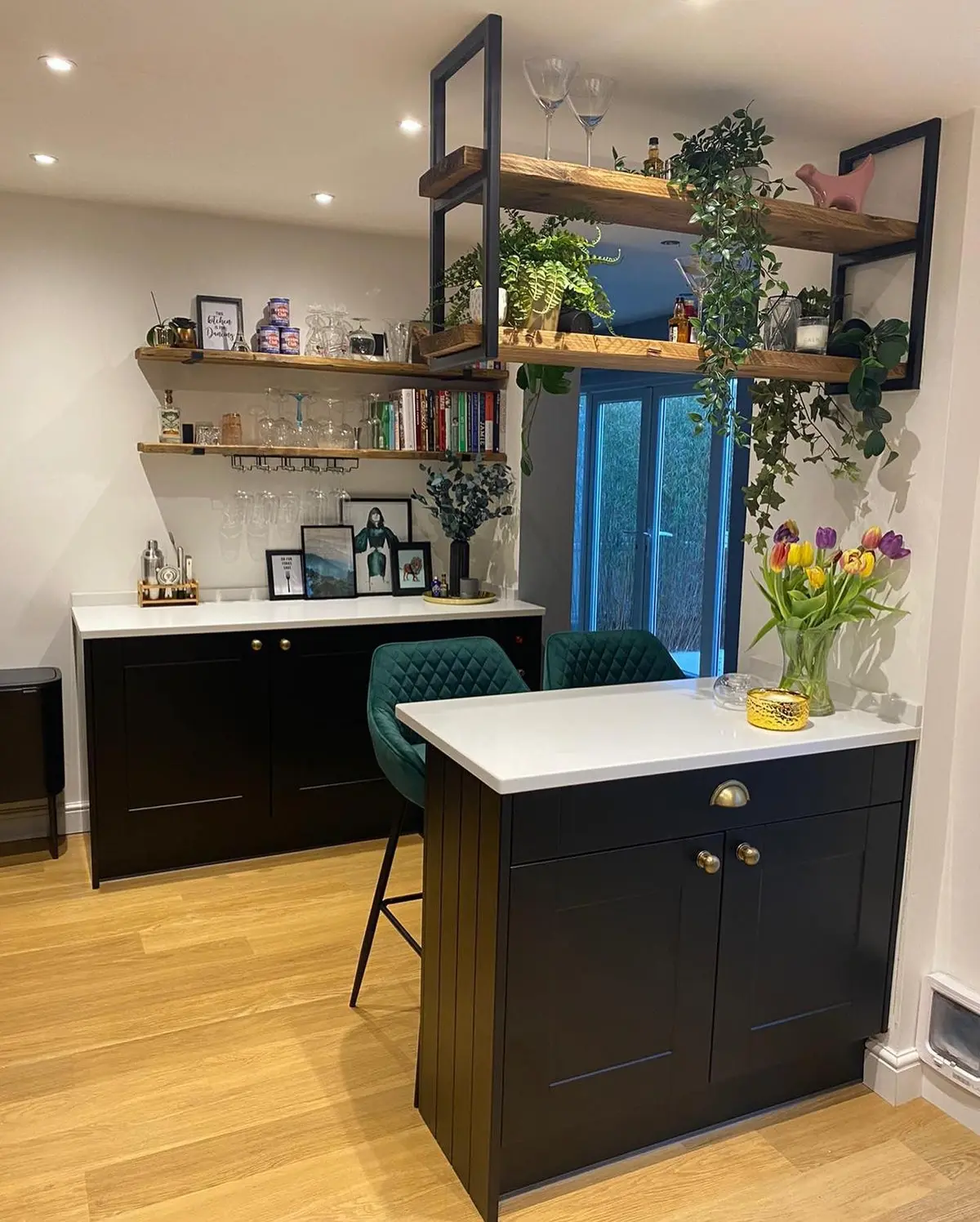 Matt black shaker peninsula with white quartz worktop and suspended shelving
