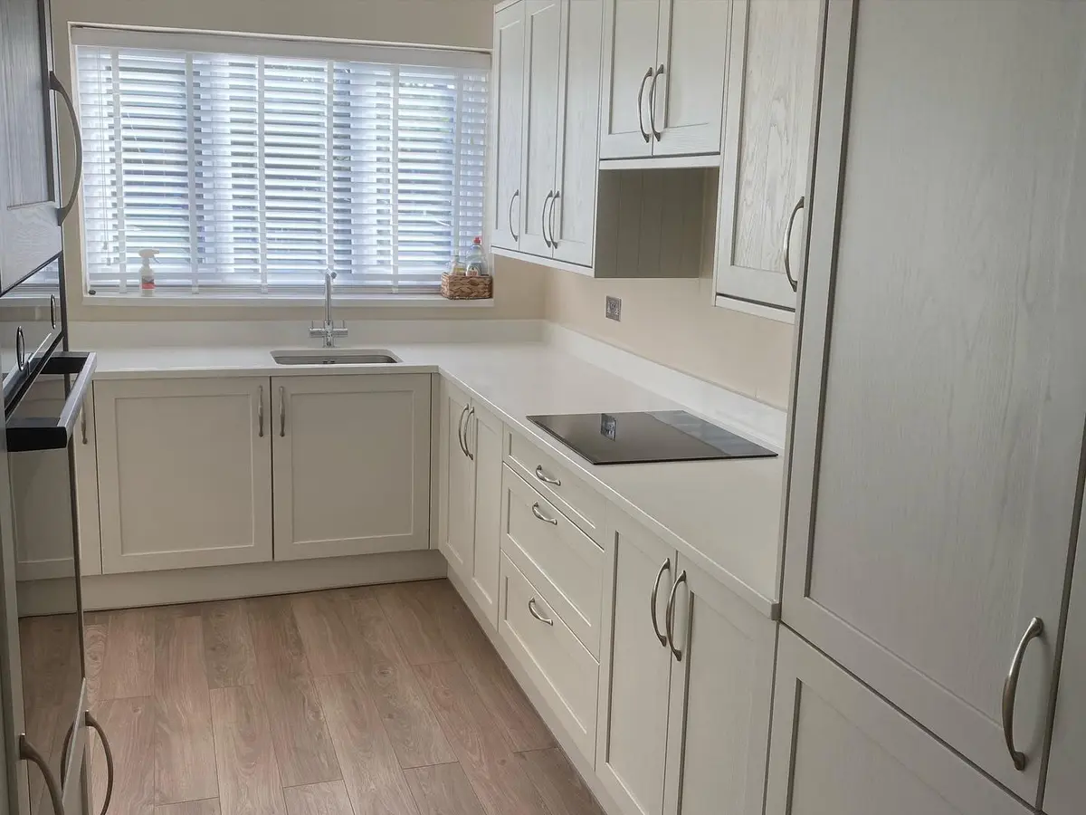 Light shaker run beneath the window with hob and quartz worktops