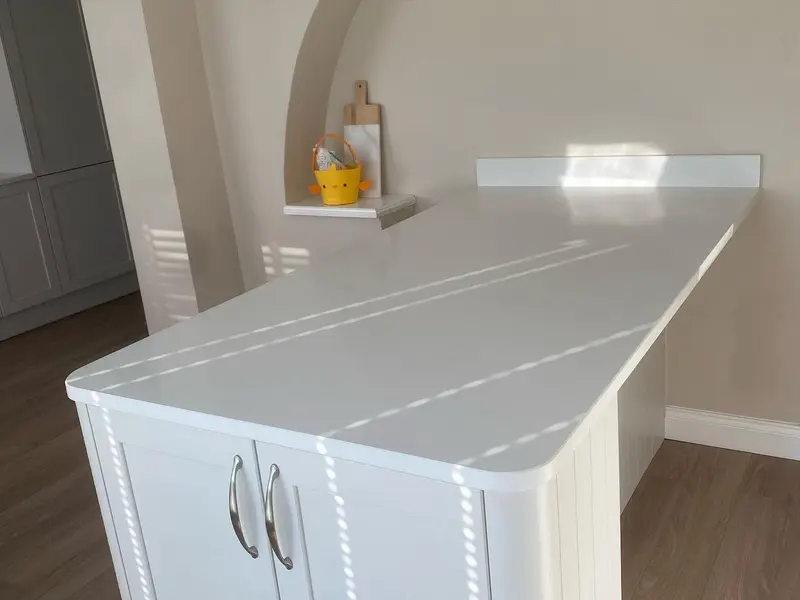 Curved-end peninsula with white quartz worktop over shaker units