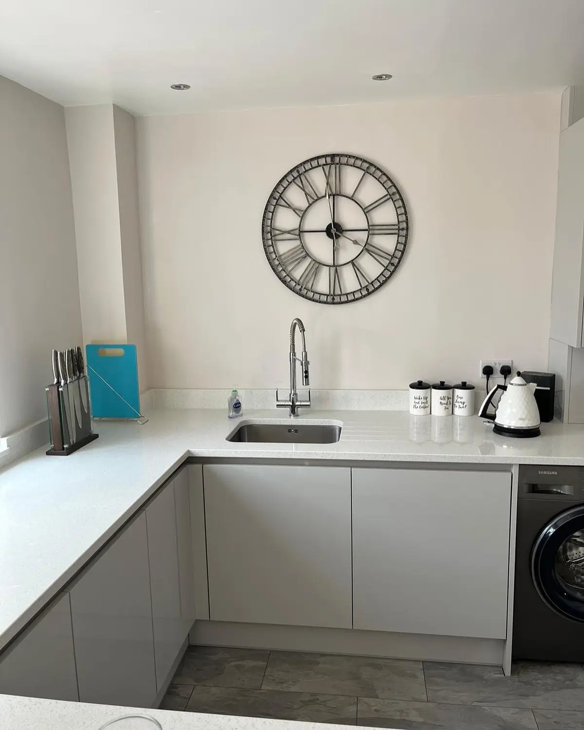 Handleless sink run under a wall clock