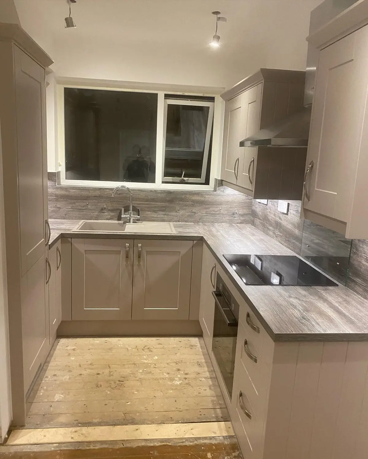 Pebble shaker sink run under the window with matching wall panels