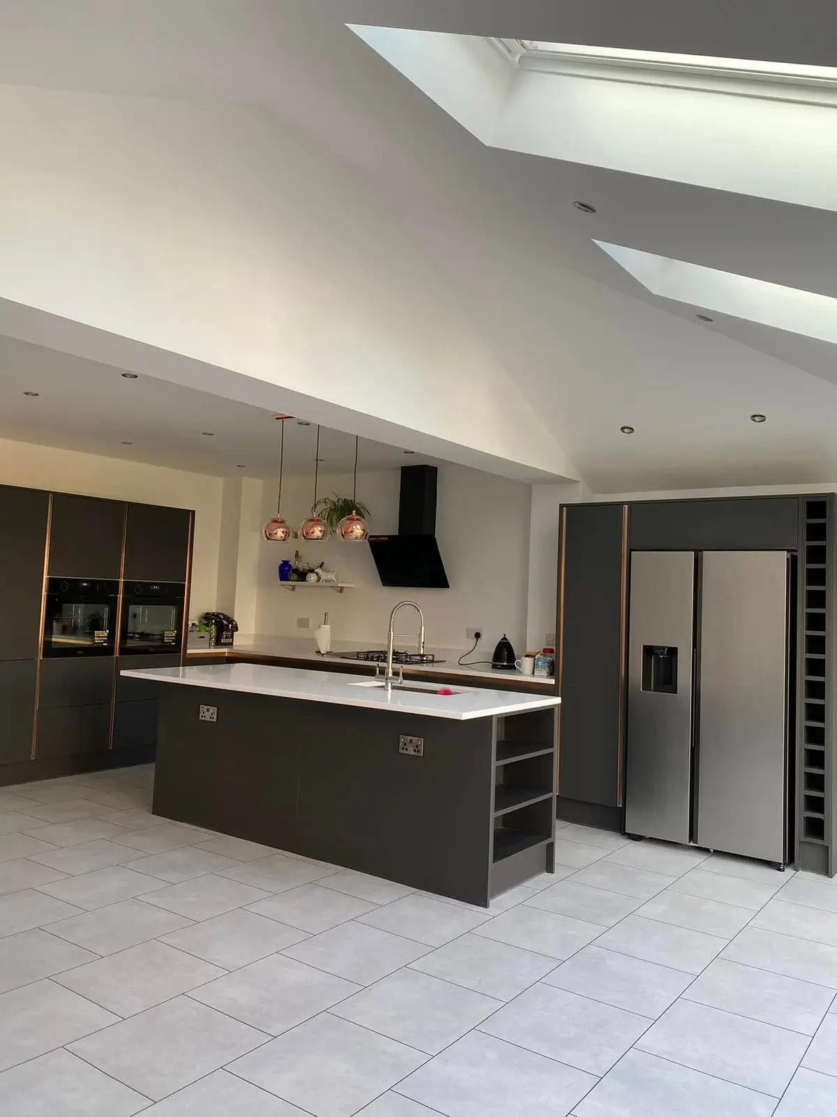 Dark grey handleless kitchen and island beneath roof windows