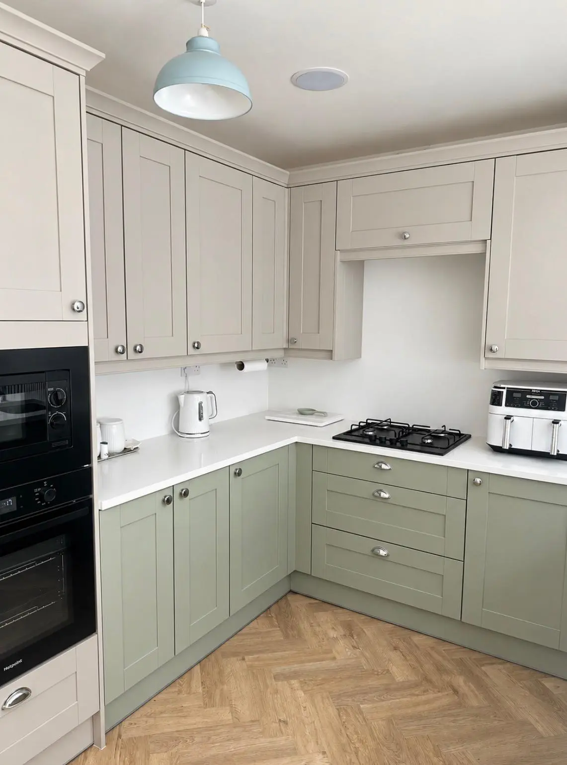 Built-in black oven and microwave in a cashmere tall housing beside the hob run
