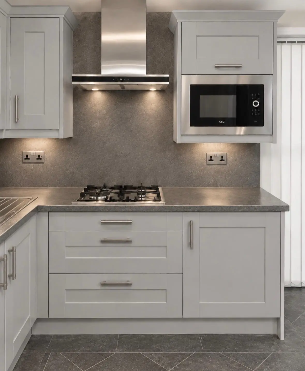 White shaker hob run with chimney extractor and built-in microwave