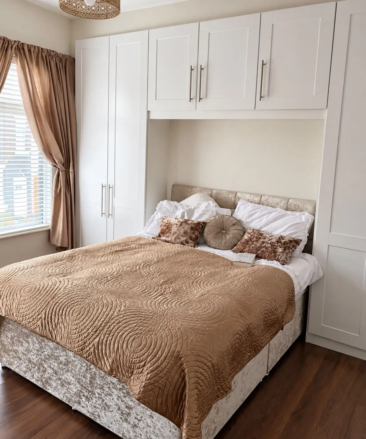 White shaker wardrobes and bridging units around the bed, beside the window